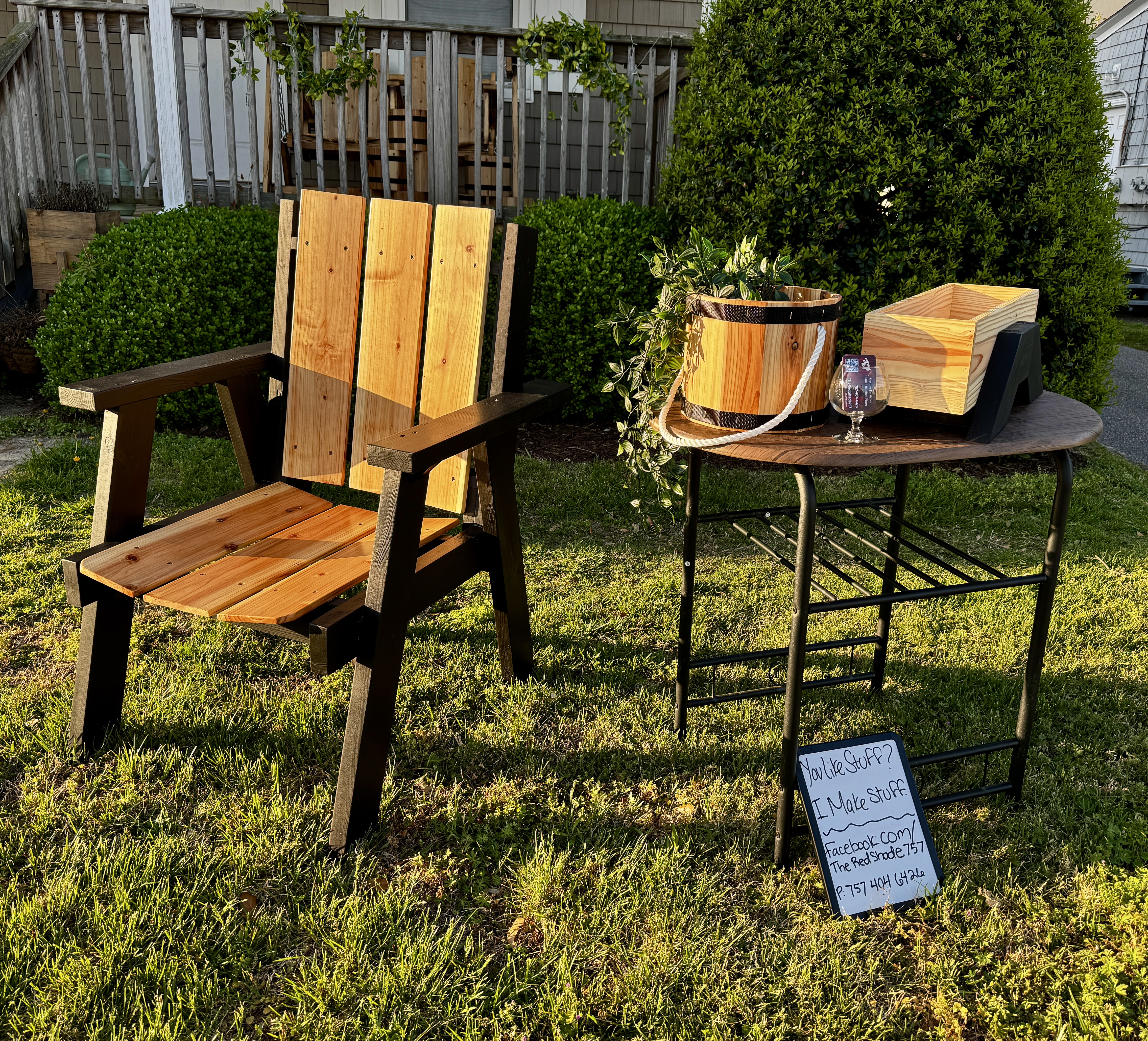 Black-frame cedar Adirondack chair with planter and bucket displayed in yard