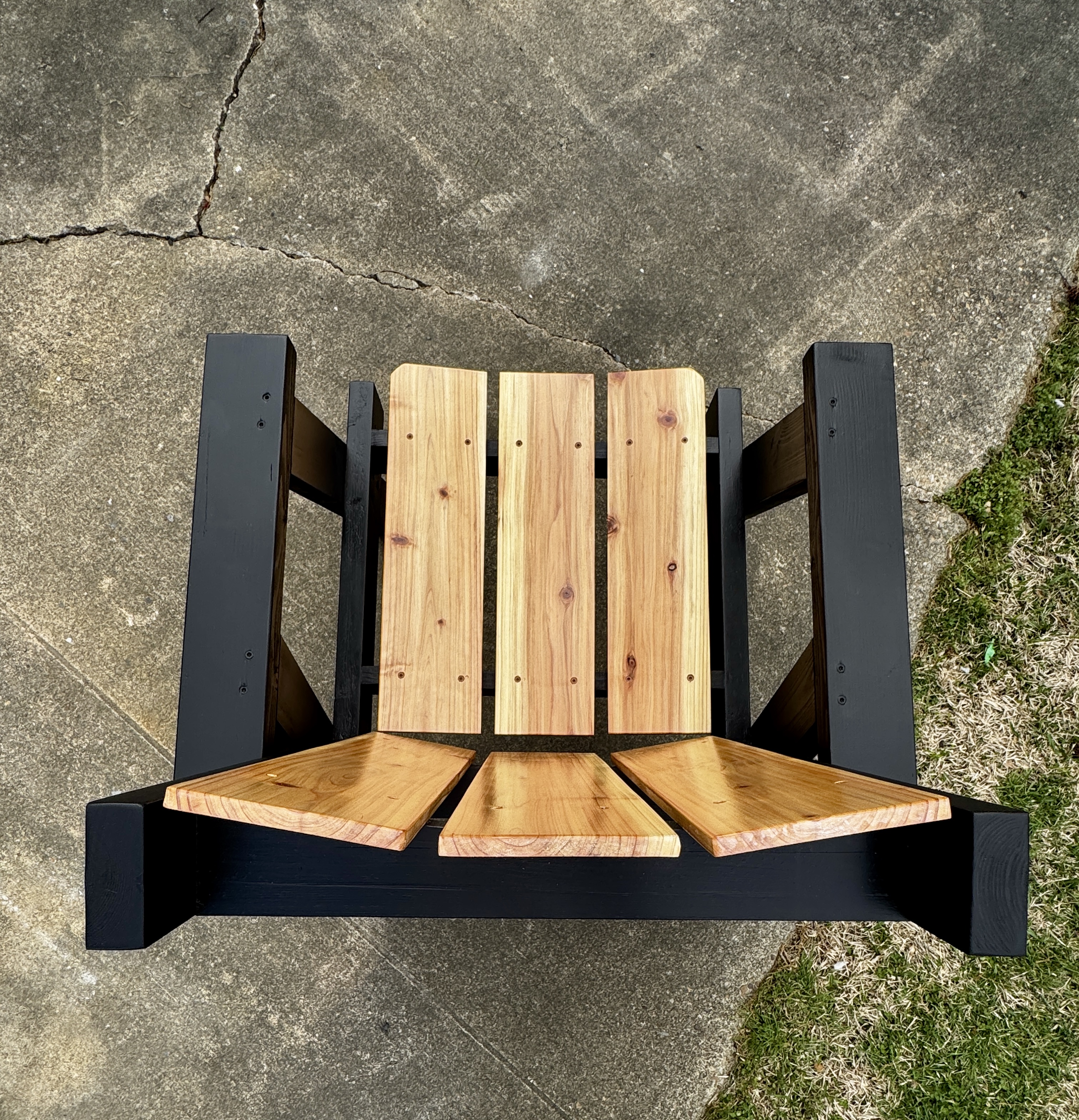 Top-down view of black-frame chair showing cedar slat layout